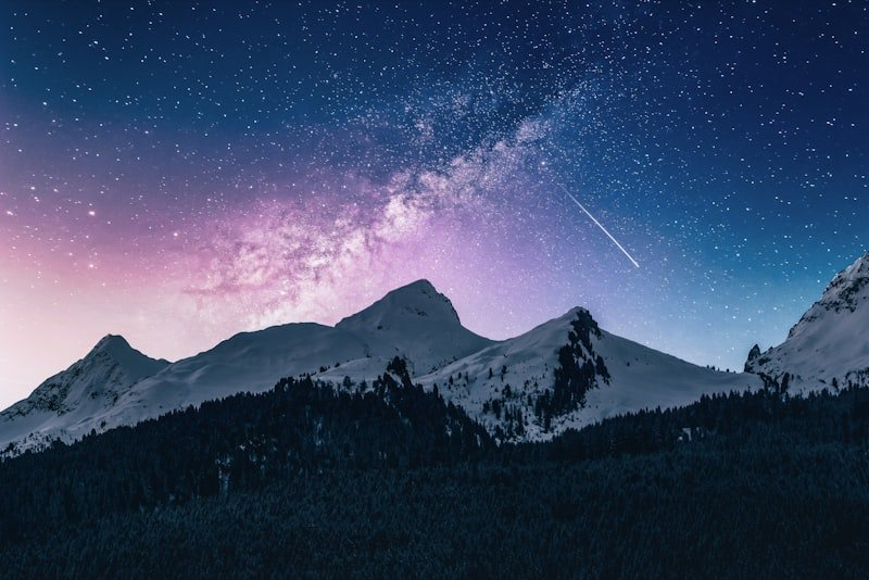 A dense field of stars above the dark line of the hills.