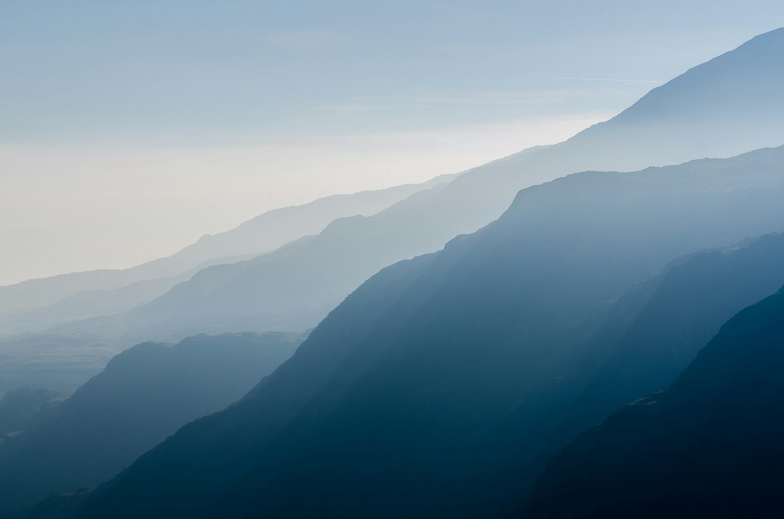 Layered ridgelines fading into morning haze.