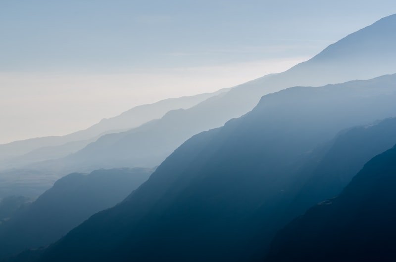 Layered ridgelines fading into morning haze.